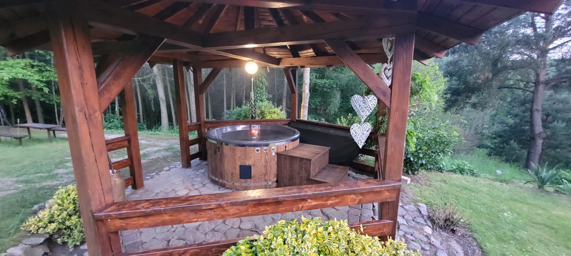 Balia ogrodowa pod altaną w otoczeniu zieleni
